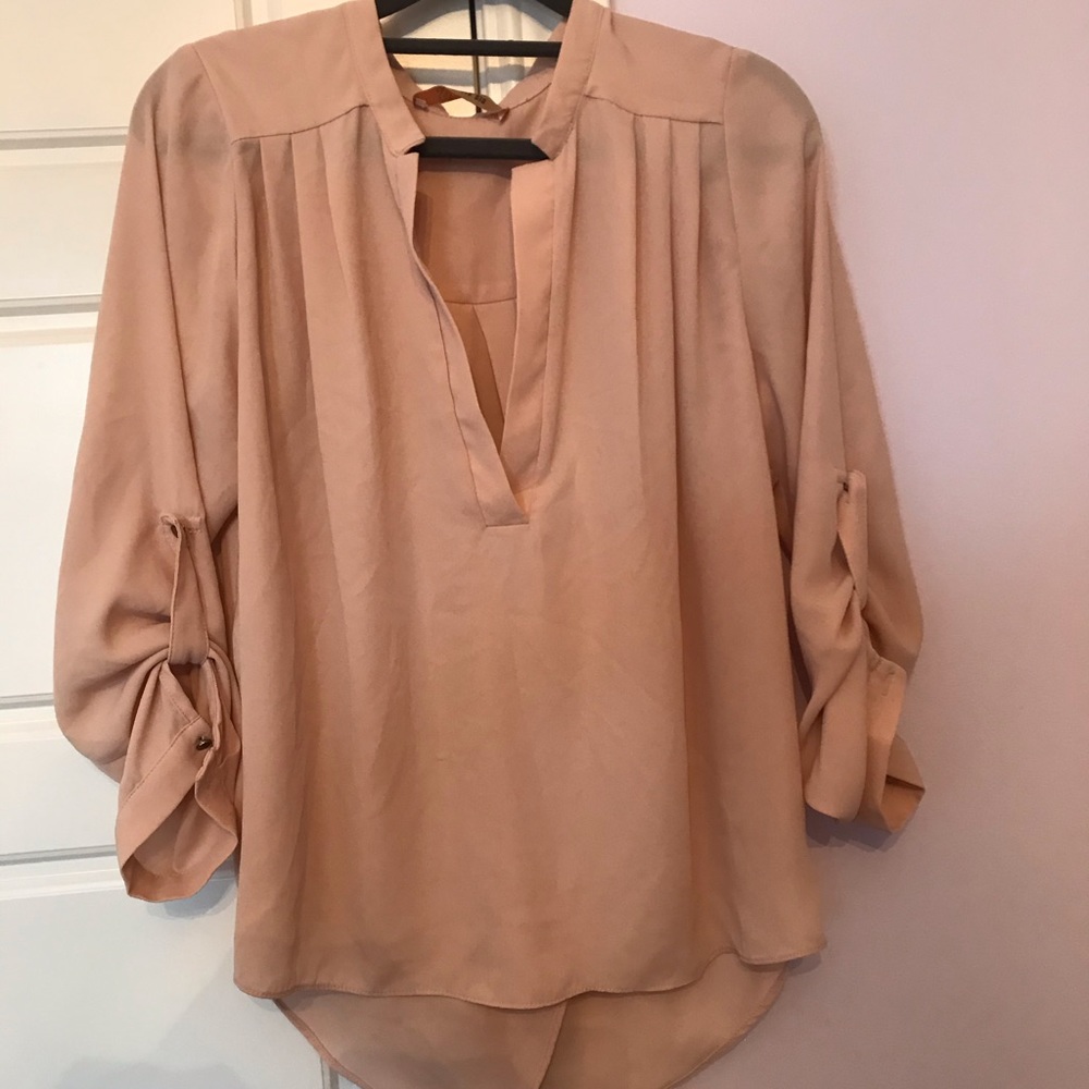Light tan silky blouse.